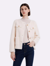 a lady in white wool cropped coat with black jeans